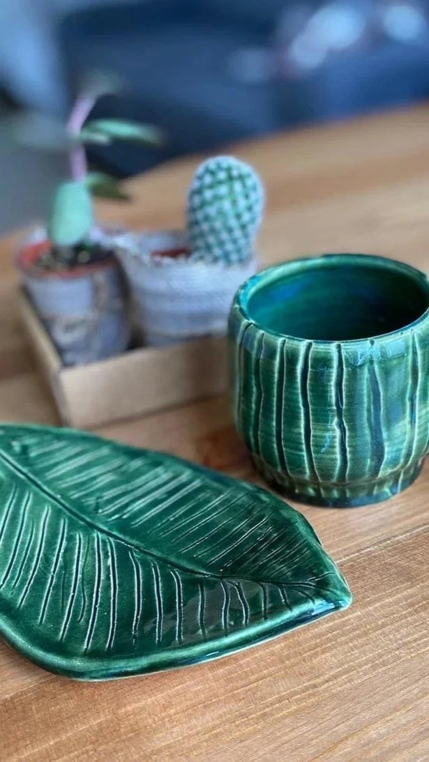 A finished clay vase with a botanical arrangement